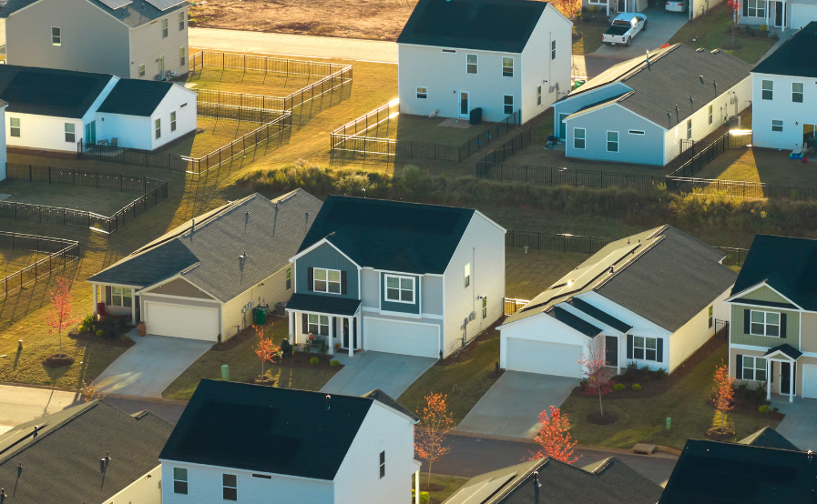 Aerial view of a clean, modern suburban neighborhood in Indiana with two-story houses and fenced backyards.