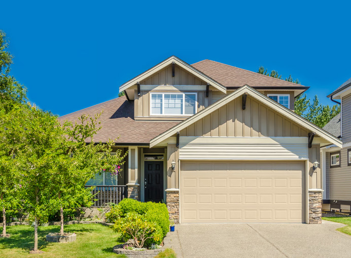 Exterior view of a modern suburban home with a garage, driveway, and front yard representing homeownership freedom.